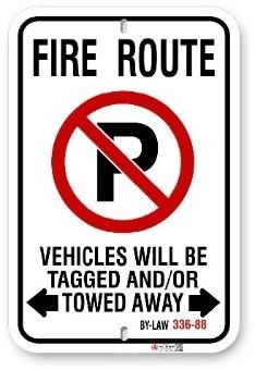 picture of fire route sign indicating no parking and vehicles will be tagged and/or towed away