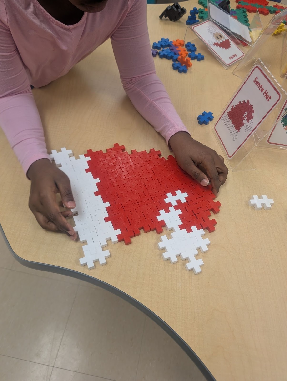 students making santa hat with plus plus blocks